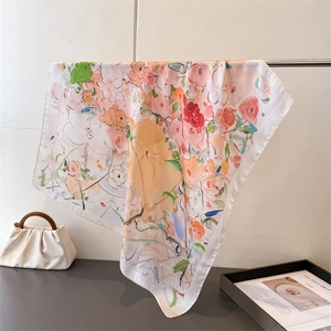 Abstract floral silk-like scarf with vibrant pink and orange prints on a metal display
