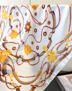 Detailed view of luxury chain and floral print on smooth faux silk square scarf