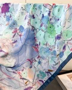 Close-up of silk scarf showing abstract oil painting print and fine blue rolled edges