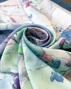 Macro shot of silk-like scarf with oil painting floral prints and rolled edges