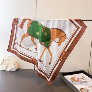 Détail d'un foulard en soie avec imprimé équestre et bordure marron dans un cadre élégant