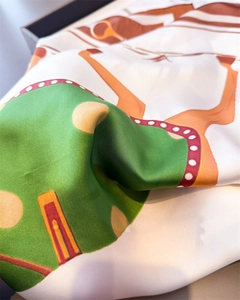 Détail d'un foulard en soie avec imprimé équestre et texture satinée luxueuse