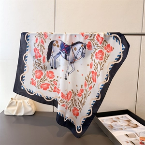 Detail of silk-like scarf featuring equestrian horse prints and red floral patterns