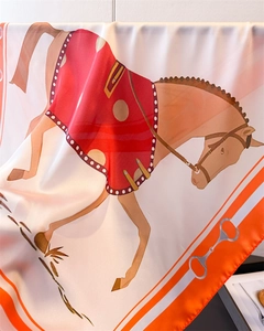 Détail d'un foulard en soie avec imprimé équestre et bordure orange de luxe