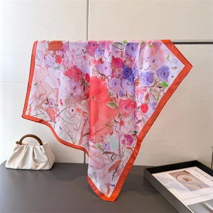 Detailed close-up of an oil painting style floral silk scarf with bright orange edges