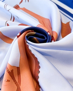 Vue macro en spirale montrant la texture de soie et l'imprimé équestre orange et bleu