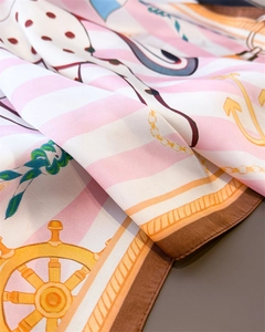 Detail of silk scarf showing nautical anchor prints and hand-rolled edges on pink stripes