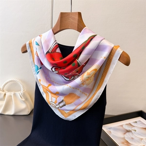 Elegant silk scarf with nautical equestrian print and gold chain patterns on a hanger
