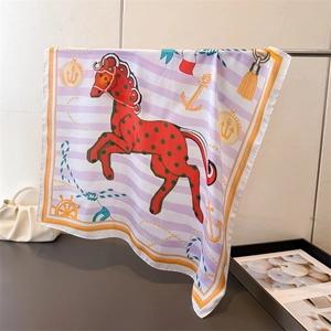 Detail of silk-like scarf featuring equestrian horse print and nautical motifs on stripe