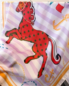 Detail of silk scarf showing equestrian print with horse, anchor motifs and satin texture
