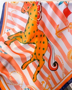 Close-up of nautical horse print silk scarf featuring vibrant orange and blue satin texture