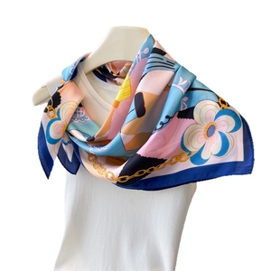 Satin scarf with blue and yellow chain print hung on a white hanger for styling