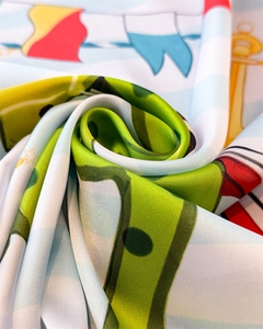 Macro detail of silk scarf showing smooth texture with nautical and equestrian patterns
