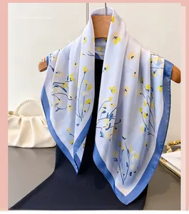 Detailed view of floral silk scarf with yellow flowers and elegant navy blue border