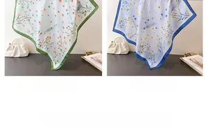 Detail of floral silk-like square scarves in green and blue colors with smooth texture