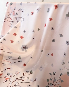 Close-up of soft pink floral silk scarf showing delicate flower print and drape