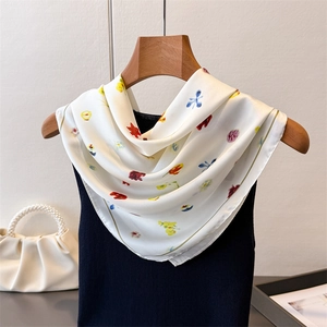 Élégant foulard en soie ivoire avec imprimé floral coloré drapé sur une tenue chic