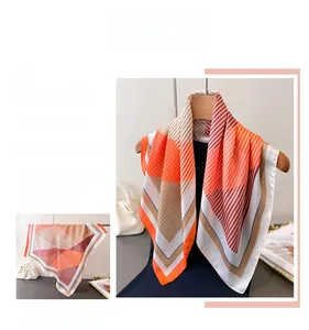 Detail of silk satin scarf with geometric stripes in orange, brown and deep red