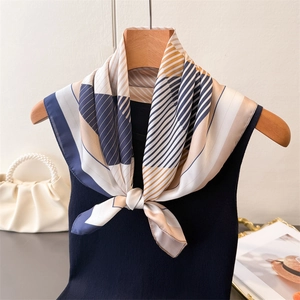 Detailed view of geometric silk scarf with navy and mustard pattern on black vest