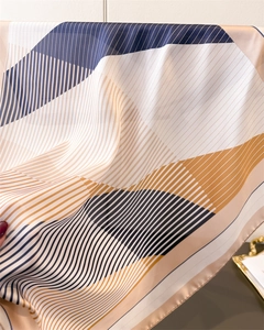 Close-up of geometric striped silk scarf showing smooth texture and elegant drape