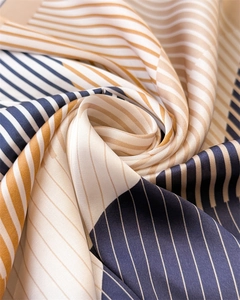 Close-up of geometric striped silk scarf featuring smooth satin texture and elegant drape