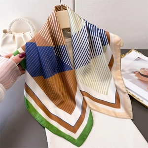 Elegant geometric print silk-like square scarf in multi-color stripes on a hanger