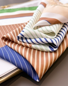 Close-up of geometric striped silk scarf showing high-quality texture and satin sheen