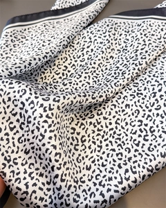 Detail of leopard print silk scarf fabric with elegant black and white striped border