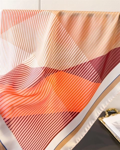 Detail of geometric stripe print silk scarf with fine edge stitching and satin sheen