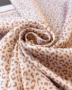 Macro shot of silk-like leopard print scarf in soft pink and brown showing smooth texture
