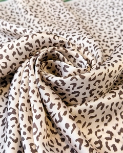 Close-up of leopard print satin fabric with smooth texture and glossy silk-like finish