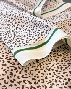 Macro detail of leopard print silk scarf with green striped hem and glossy texture
