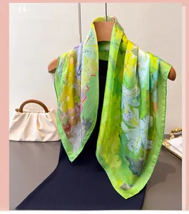 Texture détaillée d'un foulard en soie verte avec motifs floraux de peinture à l'huile