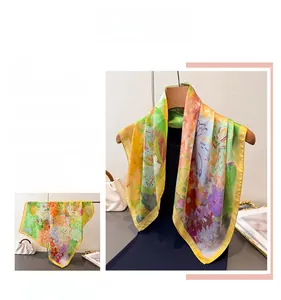 Détail d'un foulard en soie aux motifs floraux de peinture à l'huile et bords roulés jaunes