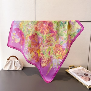 Close-up of elegant silk square scarf with abstract floral patterns and rose purple border
