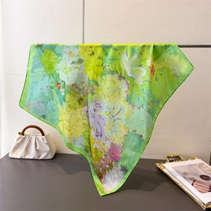 Détail d'un foulard en soie à imprimé floral suspendu à une barre métallique