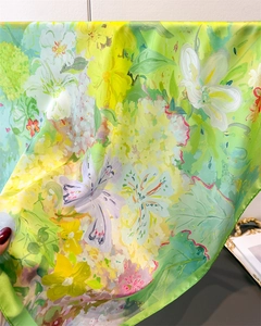 Gros plan d'imprimé floral sur foulard en soie verte avec détails de bord roulé