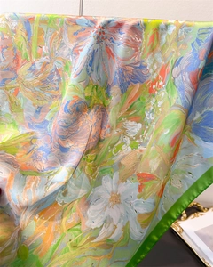 Close-up of silk-like square scarf featuring impressionist floral oil painting and green satin edges