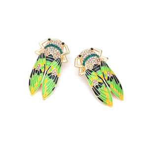 Creative gold cicada earrings with green enamel wings and sparkling rhinestones