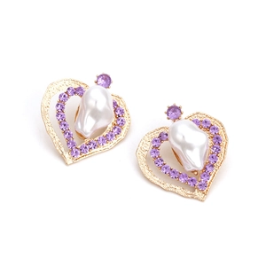 Orecchini a cuore dorati con cristalli viola e perle barocche su uno sfondo bianco