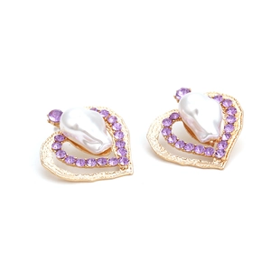 Eleganti orecchini a cuore dorati con strass viola e perle barocche su sfondo bianco