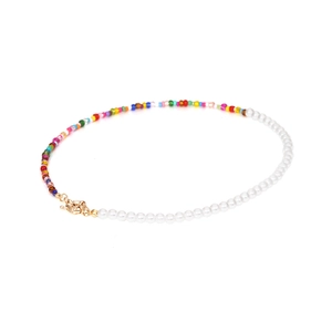 Collier bohème asymétrique avec perles blanches et perles multicolores sur fond blanc