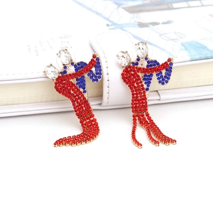 Detailed view of dancing figure earrings featuring red and blue rhinestones in gold finish