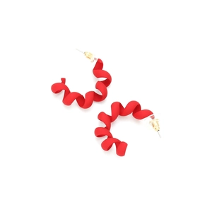 Macro detail of red spiral C-shaped earrings with a matte textured finish and gold posts