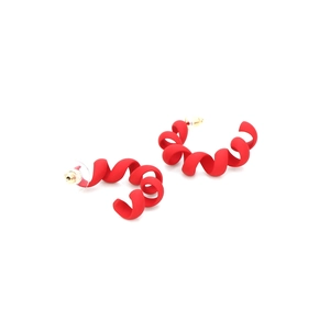 Macro shot of red spiral earrings with a matte frosted finish and gold metal hooks