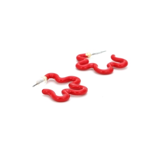 Macro detail of red wavy enamel flower earrings with polished gold-tone alloy studs