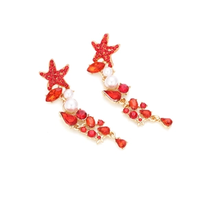 Detailed macro view of long starfish earrings with red rhinestones and white pearls
