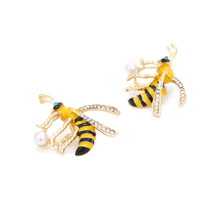 Enamel bee stud earrings with crystals and white pearls on minimalist background