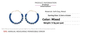 Close-up of 5.3cm blue polymer clay hoop earrings with golden metal spacers