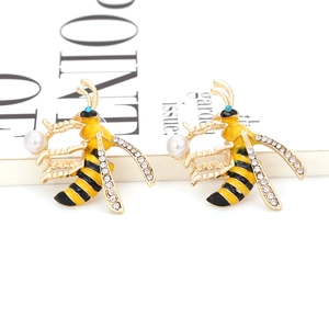 Enamel bee stud earrings with gold plating and sparkling crystals on a white background